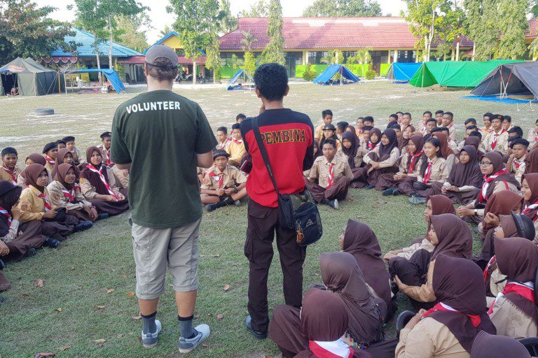 A volunteer speaking with local students