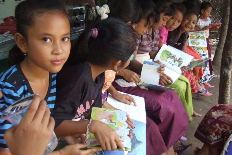 School children reading books at Friends of Nature, People and Forests' conservation center on Nusa Penida island, Bali, Indonesia